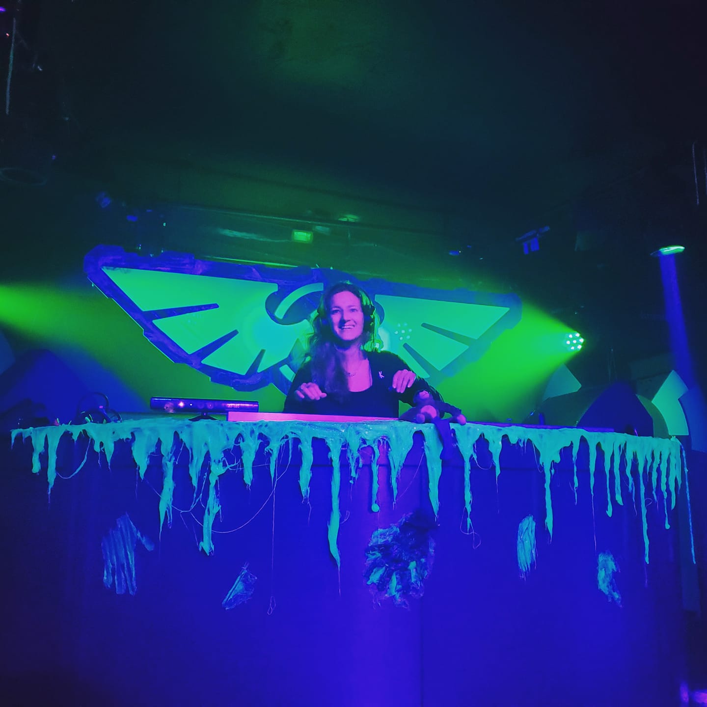 Jessica smiling while DJing in front of ICARUS logo