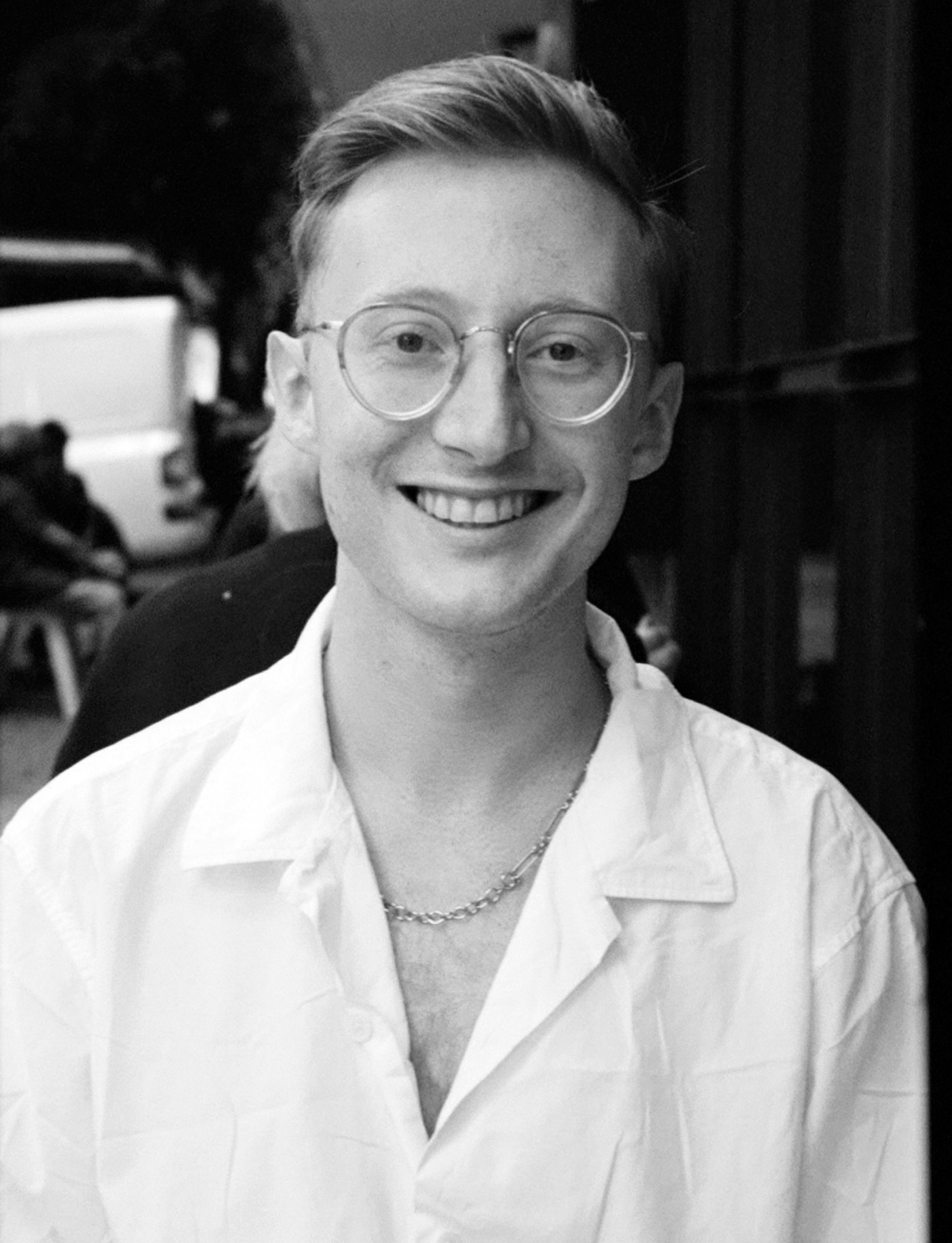 Wade Wallerstein smiles at camera in a white shirt with glasses.